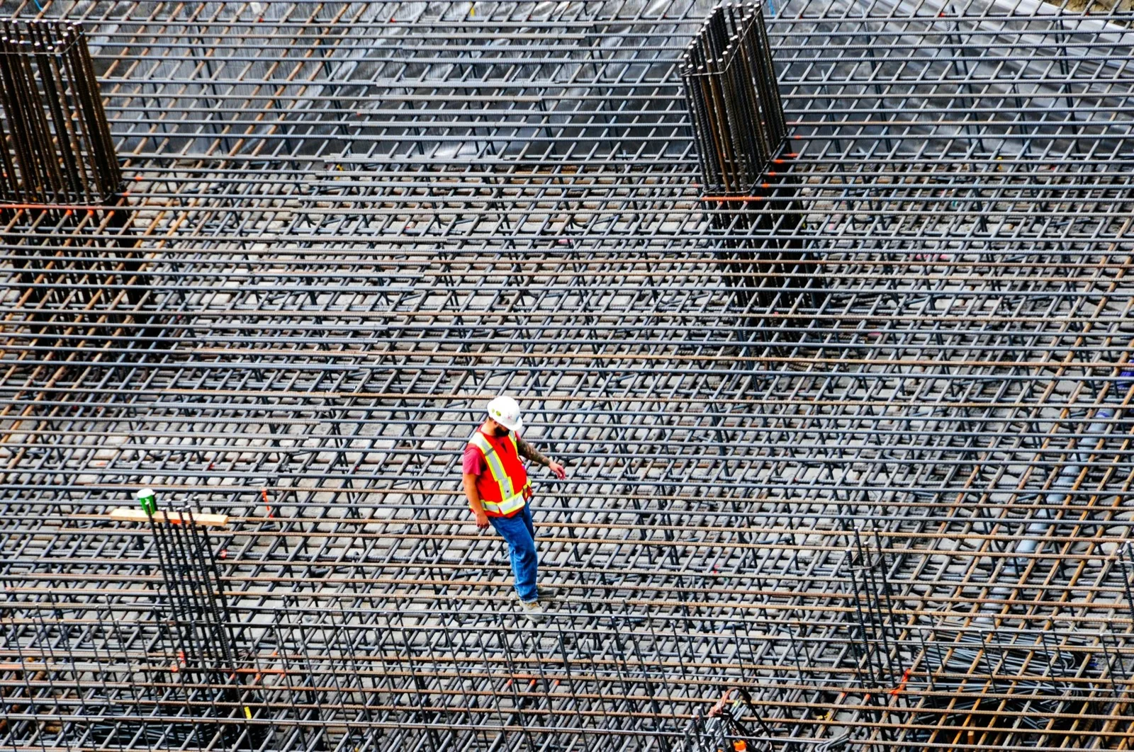 Worker inspecting a rebar mat, seen from above