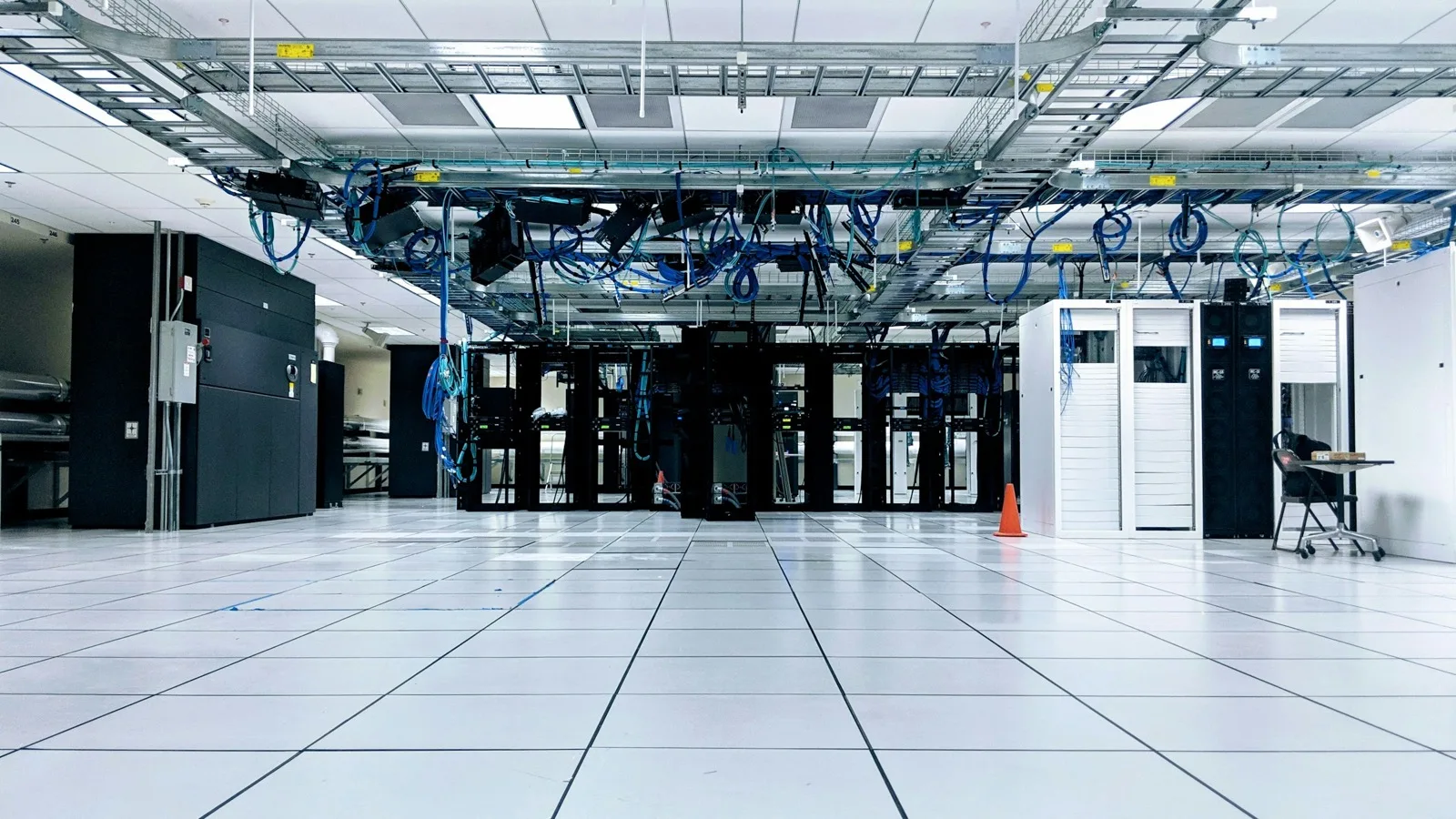 Data hall with a white raised floor and overhead cable trays